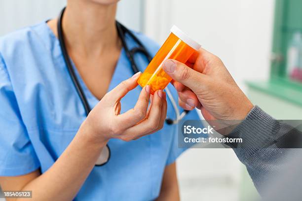 Foto de Enfermeira Dando Pílulas Para Um Paciente e mais fotos de stock de Segurar - Segurar, Medicamento receitado, Receita Médica