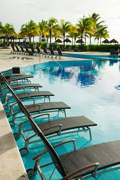 istock Tropical Beach Resort Hotel Swimming Pool with Deck Chairs 185405535