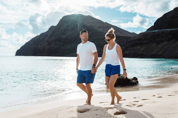 istock Happy couple enjoying relaxing walk along the beach 1854055457