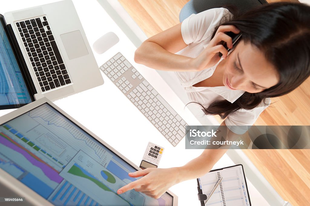 Donna d'affari alla sua scrivania al telefono - Foto stock royalty-free di Adulto