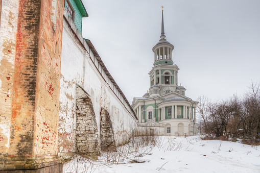 Bell tower of an old monastery of the 18th century with a defensive wall. Russia. City of Torzhok.
