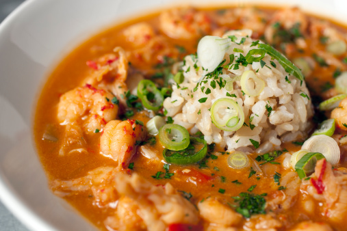 Hearty crawfish étouffée topped with a scoop of brown rice and sliced scallions