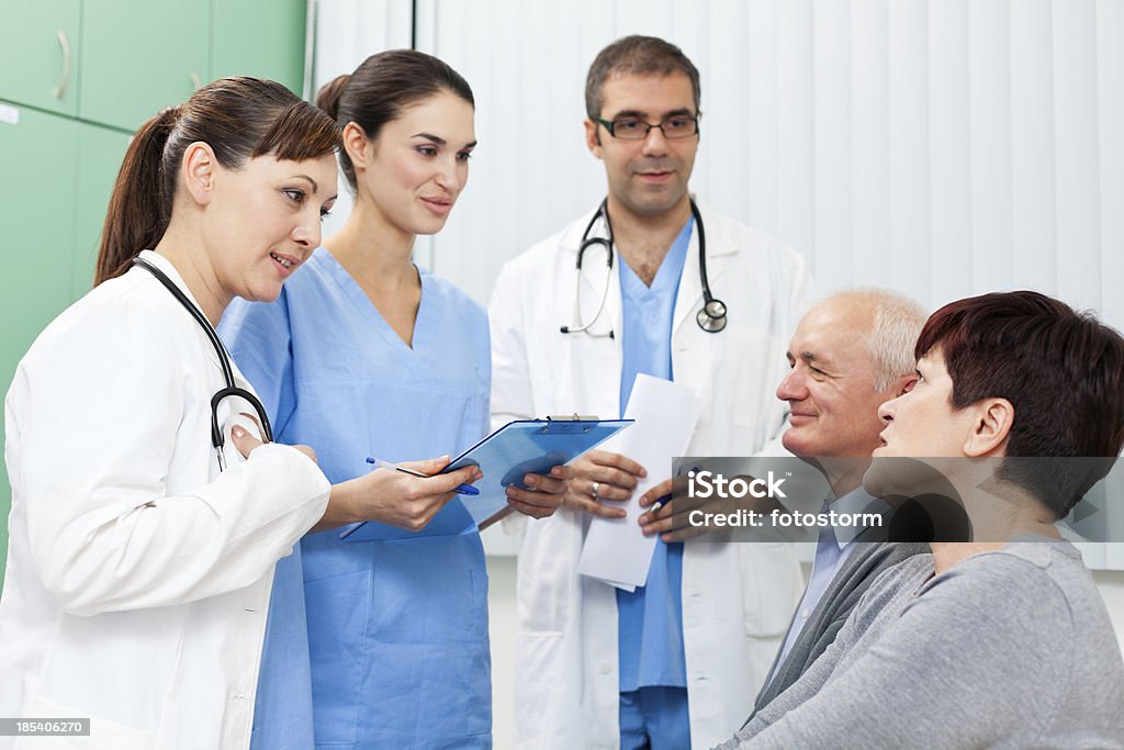 Equipo médico hablar con los pacientes en la sala de espera - Foto de stock de Doctor libre de derechos