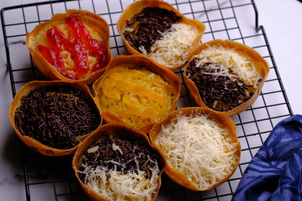 Martabak Manis. Sweet martabak. Sweet snack made from flour, eggs, vanilla, topped with grated cheese, chocolate meses, jam and pineapple, strawberry jam. Served on a cooling rack. Indonesian food. Martabak Manis. Sweet martabak. Sweet snack made from flour, eggs, vanilla, topped with grated cheese, chocolate meses, jam and pineapple, strawberry jam. Served on a cooling rack. Indonesian food. mm21 stock pictures, royalty-free photos & images
