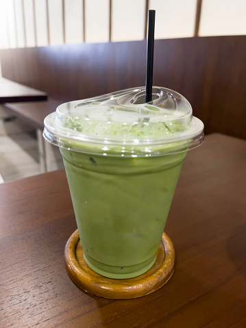 Iced milk green tea in plastic cup, stock photo