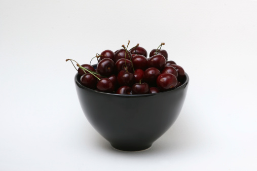 Bowl of sweet cherries on a white background