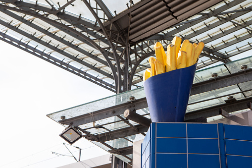 Large, artificial box of chips on top of a fast food outlet outside Cologne Central railway station