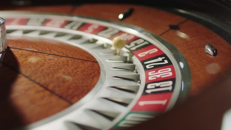 Slow motion closeup footage of the white ball on a spinning roulette wheel