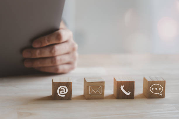 istock Website page contact us or e-mail marketing concept, Customer support hotline Contact us people connection. cube wood with the email, call phone, address, Chat message icons. on wood table. 1854176324