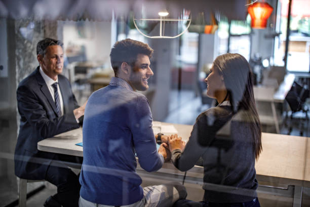istock Happy couple talking while having a meeting with their agent. 1854177915