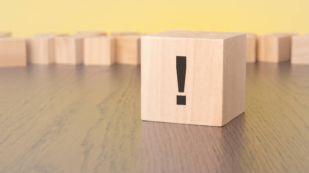 istock wooden block with exclamation point on wooden table, close up. space for text 1854190517