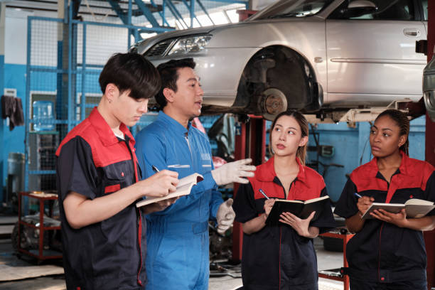 istock A supervisor engineer is training mechanic workers about car repair at a garage. 1854193160