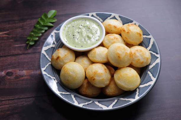 istock Paniyaram are savory balls made using fermented rice and urad dal batter along with tempered onion and spices. Also known as Paddu, Ponganalu, Kuli, bugga, and appe. served with coconut chutney 1854210779
