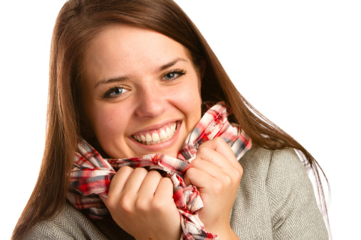 This is a shot of a beautiful young woman clutching her plaid scarf. Shot on a white background.