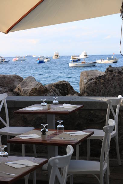 istock Umbrellas of a romantic seaside restaurant. In the background th 1854215523