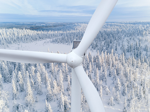 Wind turbine. Aerial view of wind turbine closeup and snow covered woods in winter Finland.