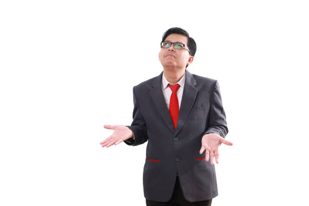 Confused asian businessman standing while looking above. Isolated on white