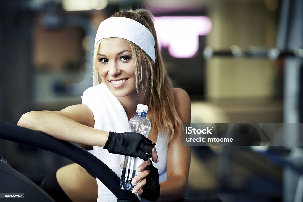 Fitness on a treadmill Smiling athletic woman resting on a treadmill Active Lifestyle Stock Photo