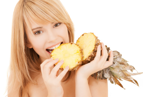 healty food and nutrition concept - happy girl with pineapple
