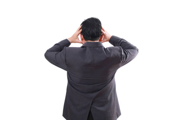 istock Back view of Stressed asian businessman standing while holding his head. Isolated on white 1854232831