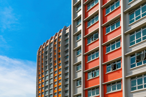 A close up shot of a new colorful high rise apartment against the sky.
