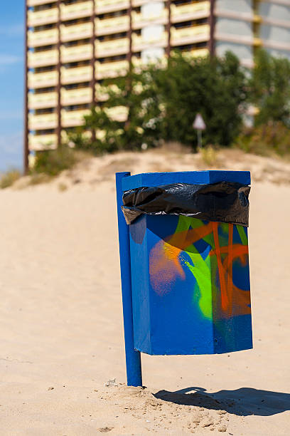 istock Blue trash basket with grafitti on the beach. 185424851