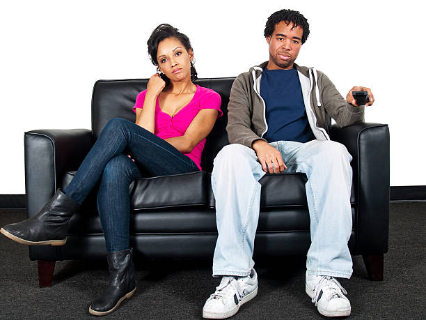 istock Couple on a Couch Channel Surfing on TV with Remote 185428535