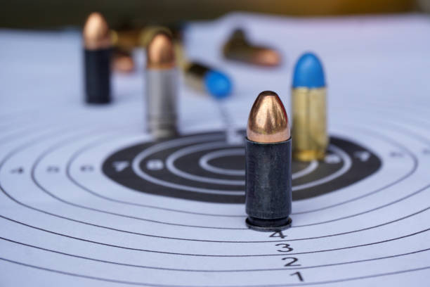 istock Black 9mm bullets on shooting target paper 1854288391