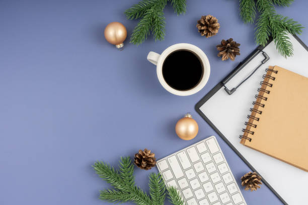 istock Christmas concept. Computer Keyboard, Clipboard, notepad, cup of coffee and christmas decoration on pastel blue background. 1854304561
