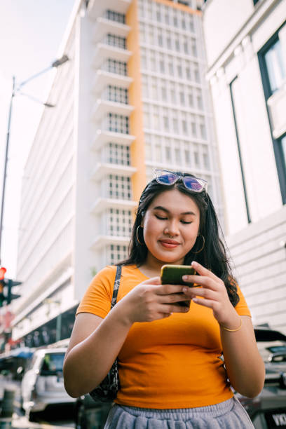 istock Young Asian Woman Using Smartphone While Walking Around The city. 1854339216