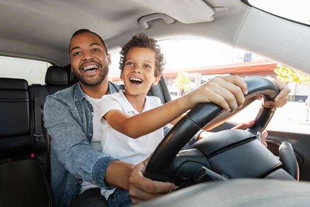 istock Joyful black father and son spend time together, driving car 1854345511