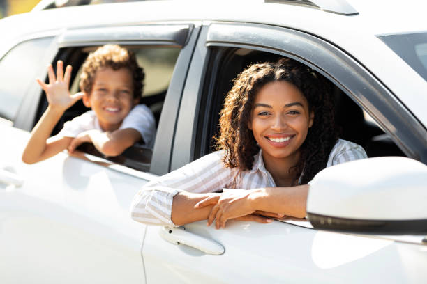 istock Happy black mother and child looking from white car windows 1854350565