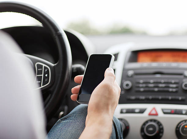 istock Medium shot of male hand holding a phone whilst inside a car 185436629