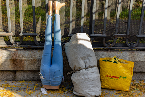 El Rastro Flea Market, Madrid, Spain. Mannequin with jeans, overturned on the sidewalk. Setting up the street vendor stall at the flea market.