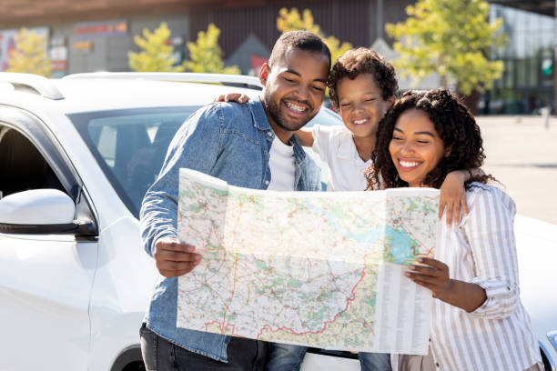 istock Cheerful black family going car trip together, checking map 1854443309