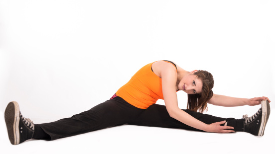 Attractive happy female athlete doing stretching exercises