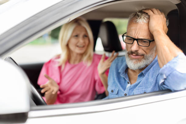 車に座っているストレスのある年配の男性は、妻と喧嘩をしています - couple arguing senior adult conflict ストックフォトと画像