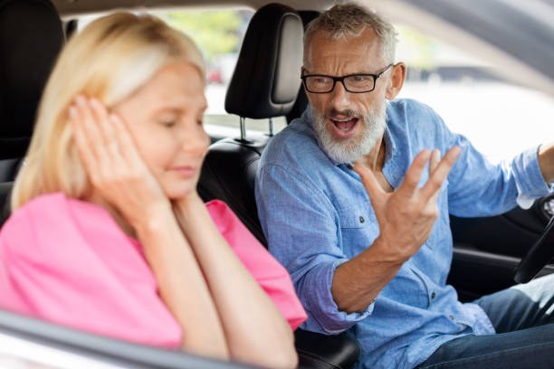イライラした怒っている先輩の男性ドライバーがストレスを抱えた妻に叫ぶ - arguing senior adult conflict couple ストックフォトと画像