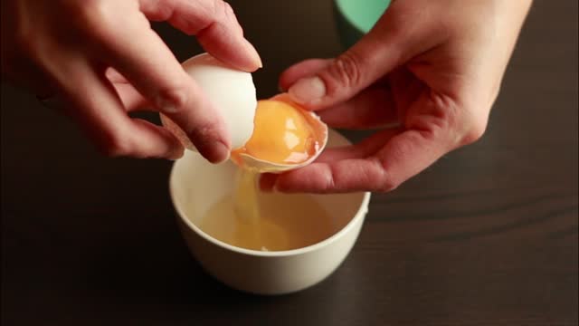 Woman's Hand Separating Egg Whites from Yolks Close-Up