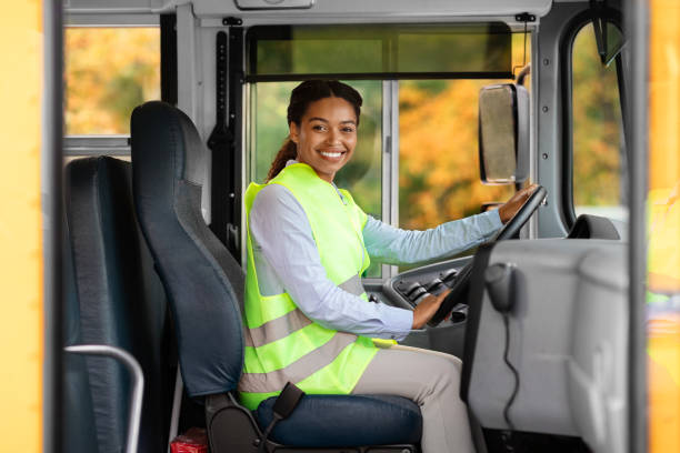 istock Happy black female driver sitting in bus and looking at camera 1854474406