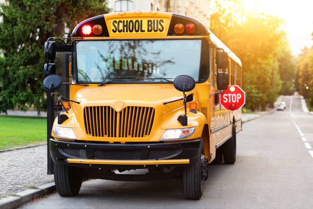 istock Old-fashioned yellow school bus with red stop sign on the side 1854476601
