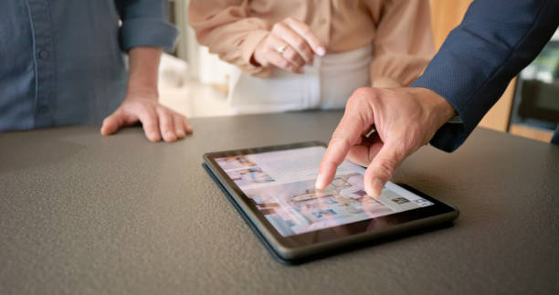 istock Male estate agent showing brochure on digital tablet 1854478244