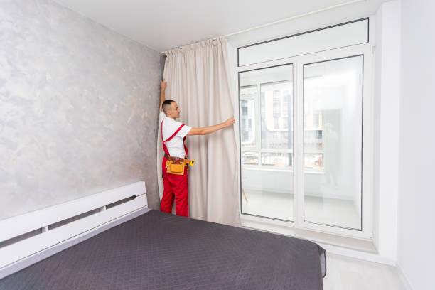 istock Man hanging window curtain indoors. Interior decor element 1854478298