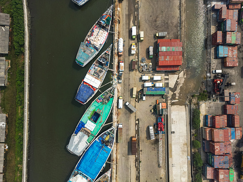 Aerial drone view of wooden boats leaning beside the pier. 
Sunda Kelapa is the old port of Jakarta, located on the estuary of the Ciliwung River.

Jakarta, Indonesia