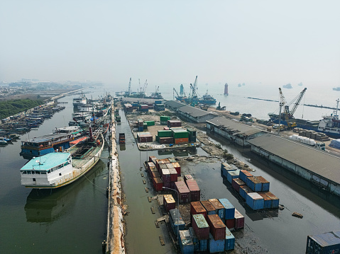 Aerial drone view of wooden boats leaning beside the pier. \nSunda Kelapa is the old port of Jakarta, located on the estuary of the Ciliwung River.\n\nJakarta, Indonesia