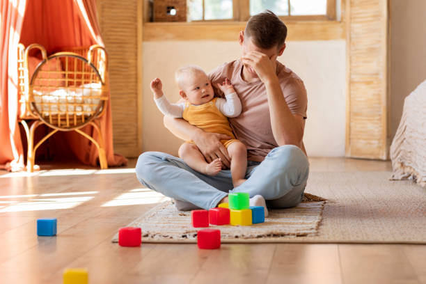 istock Single Dad Problems. Man Feeling Tired Of Taking Care About Infant Baby 1854482156