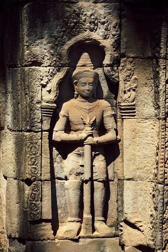 Ancient soldier bas-relief on a wall at Banteay Kdei temple ruins, in Angkor Wat complex near Siem Reap, Cambodia.