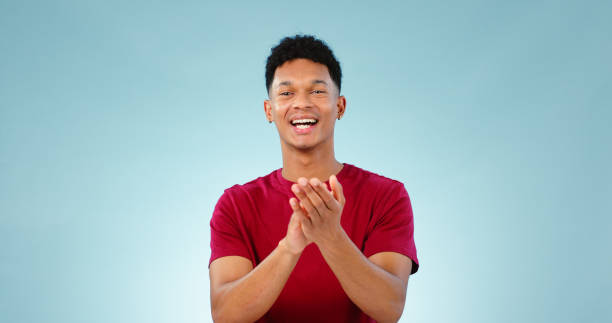 istock Man, portrait and clapping for celebration in studio for goal growth, winning or opportunity. Male person, face and hand applause on blue background as mockup or achievement, congratulations or pride 1854492169
