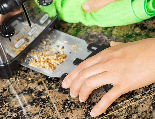 Removing bread crumbs from Kitchen Tray Toaster stock photo