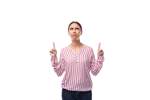 young brunette business woman dressed in a striped shirt thinking on a white background.